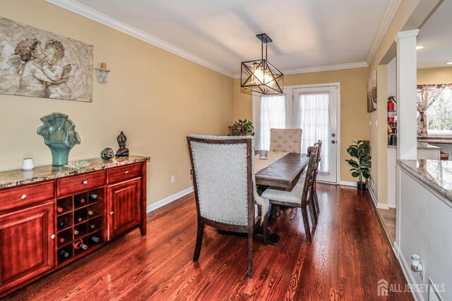 dining room with ornate columns, ornamental molding, and dark hardwood / wood-style flooring