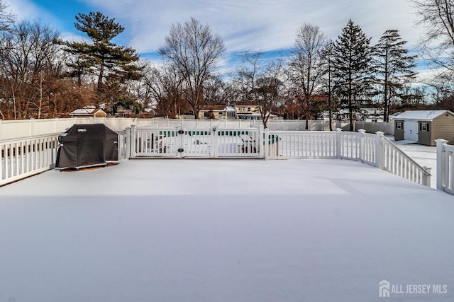 view of patio / terrace featuring a pool, a storage shed, and a grill