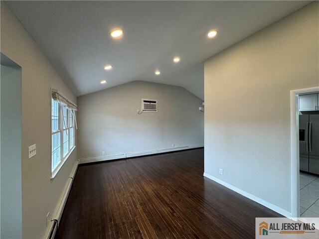 interior space with vaulted ceiling, dark wood-type flooring, a wall mounted air conditioner, and a baseboard radiator