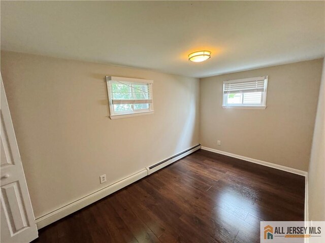 empty room with a baseboard radiator and dark wood-type flooring