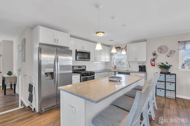 318 Bayview Ave, Union Beach, NJ 07735 - kitchen featuring stainless steel appliances, dark wood-style floors, white cabinetry, a kitchen island, and baseboards