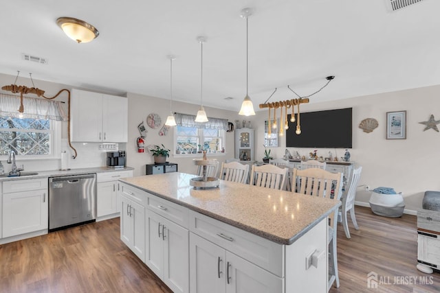 318 Bayview Ave, Union Beach, NJ 07735 - kitchen with dishwasher, a kitchen island, a sink, wood finished floors, and white cabinets