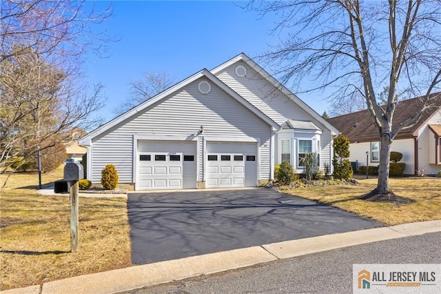 ranch-style home featuring aphalt driveway, an attached garage, and a front yard