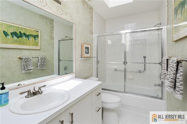 full bath featuring tile patterned floors, combined bath / shower with glass door, toilet, and vanity