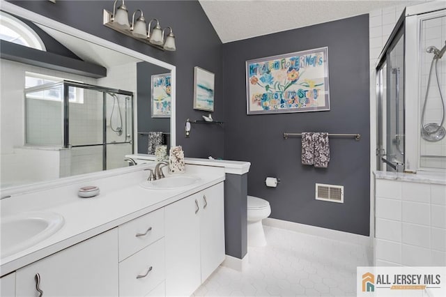 bathroom with tile patterned flooring, a shower stall, visible vents, and a sink