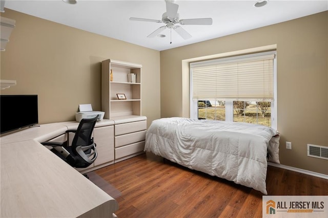 bedroom with visible vents, a ceiling fan, and wood finished floors