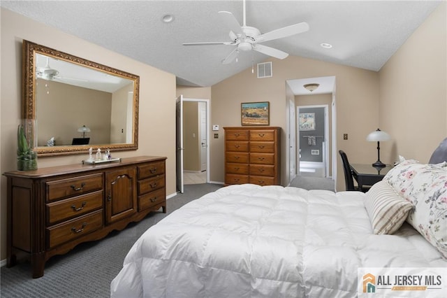 bedroom featuring a ceiling fan, visible vents, lofted ceiling, a textured ceiling, and dark carpet