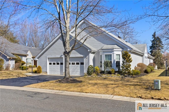 view of front of house with aphalt driveway, a front yard, and an attached garage