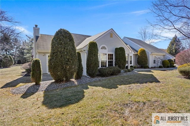 view of front of property featuring a chimney and a front yard