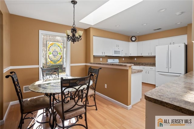 kitchen featuring visible vents, light wood-style flooring, white appliances, and white cabinetry