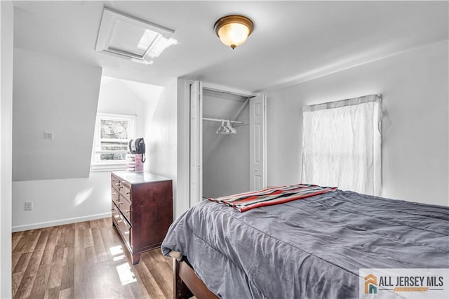 20 Cedar Ave, North Brunswick, NJ 08902 - bedroom featuring attic access, wood finished floors, vaulted ceiling, a closet, and baseboards