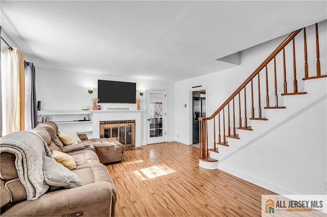 20 Cedar Ave, North Brunswick, NJ 08902 - living room with light wood-type flooring, stairs, a brick fireplace, and baseboards