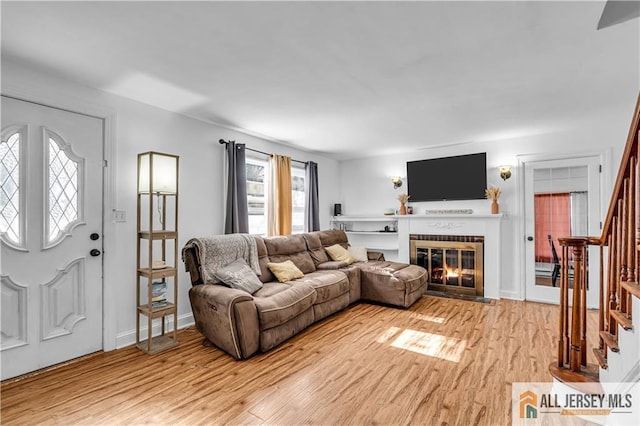 20 Cedar Ave, North Brunswick, NJ 08902 - living area with stairs, light wood finished floors, and a fireplace with flush hearth
