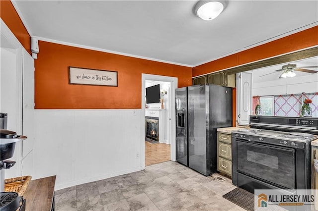 20 Cedar Ave, North Brunswick, NJ 08902 - kitchen with black range with electric cooktop, stainless steel fridge, ceiling fan, a fireplace with flush hearth, and ornamental molding
