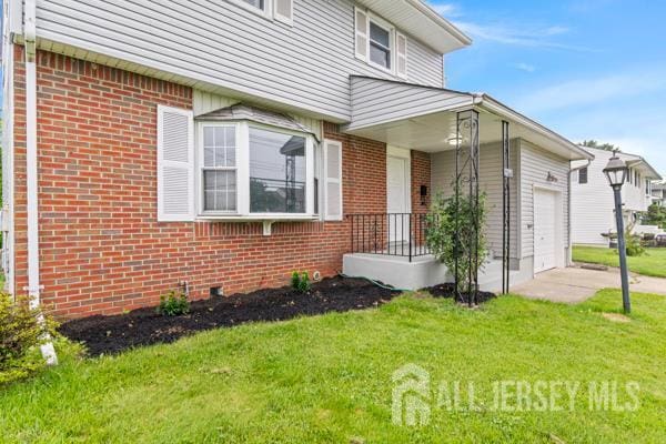 2164 Whitehorse Hamilton Square Rd, Hamilton, NJ 08690 - doorway to property featuring brick siding, a lawn, and an attached garage