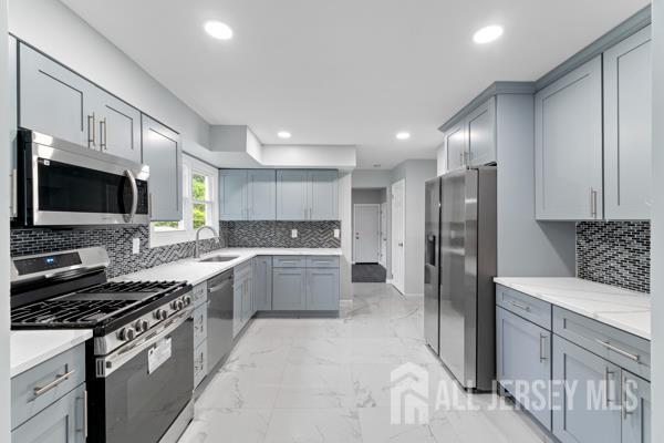 2164 Whitehorse Hamilton Square Rd, Hamilton, NJ 08690 - kitchen with stainless steel appliances, gray cabinets, light marble finish flooring, recessed lighting, and tasteful backsplash