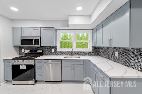 2164 Whitehorse Hamilton Square Rd, Hamilton, NJ 08690 - kitchen with stainless steel appliances, gray cabinets, light stone counters, decorative backsplash, and recessed lighting