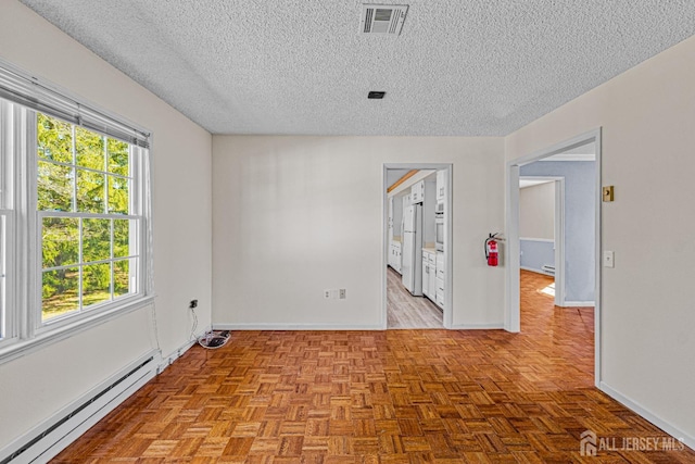 553-N Tilton Way, Monroe, NJ 08831 - unfurnished room with a baseboard radiator, a textured ceiling, and baseboards