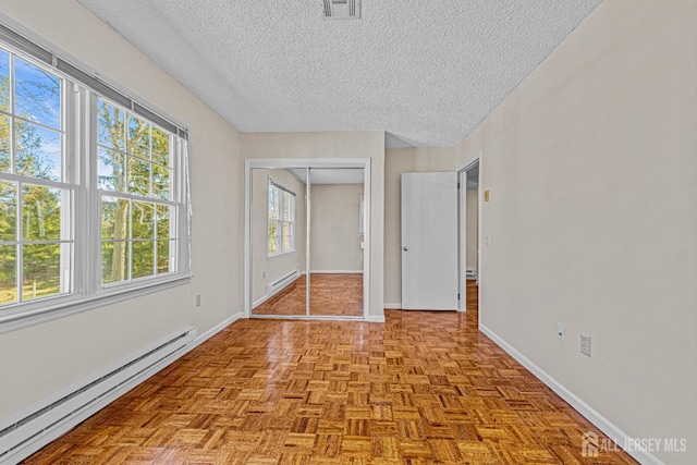 553-N Tilton Way, Monroe, NJ 08831 - empty room with a baseboard radiator, a textured ceiling, and baseboards