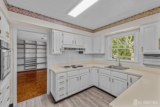 553-N Tilton Way, Monroe, NJ 08831 - kitchen with a sink, white electric cooktop, stainless steel oven, backsplash, and light countertops