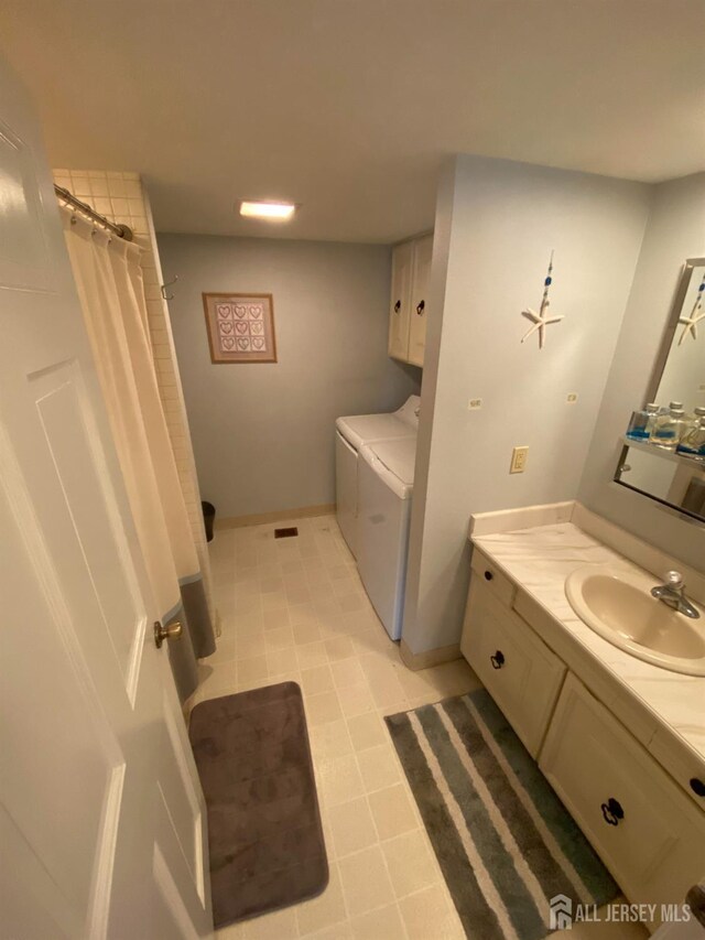 bathroom featuring a shower with curtain, independent washer and dryer, and vanity