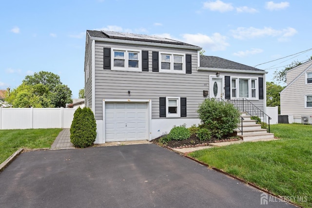 315 D St, Middlesex, NJ 08846 - split level home featuring roof mounted solar panels, a garage, driveway, and roof with shingles