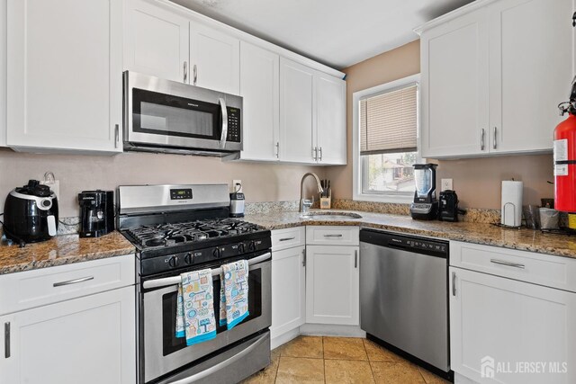 315 D St, Middlesex, NJ 08846 - kitchen featuring stainless steel appliances, a sink, white cabinets, light stone countertops, and light tile patterned flooring