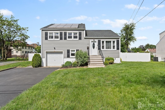 315 D St, Middlesex, NJ 08846 - split level home featuring roof mounted solar panels, an attached garage, central AC unit, driveway, and a shingled roof