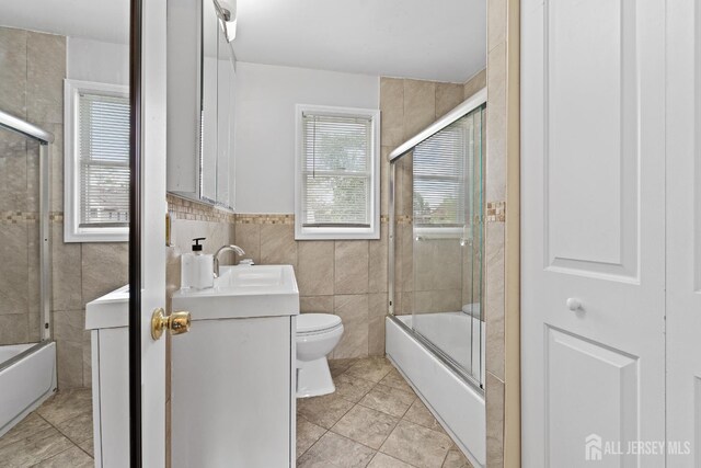 315 D St, Middlesex, NJ 08846 - full bath featuring tile walls, vanity, toilet, combined bath / shower with glass door, and tile patterned flooring