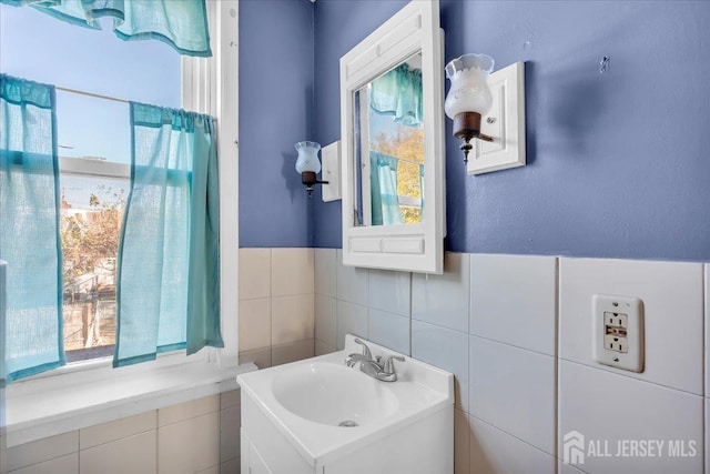 bathroom with vanity and tile walls