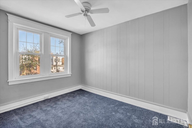 carpeted spare room with ceiling fan