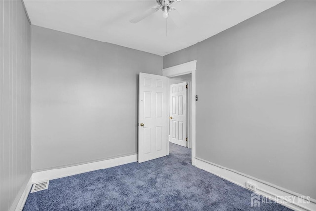 carpeted spare room featuring ceiling fan