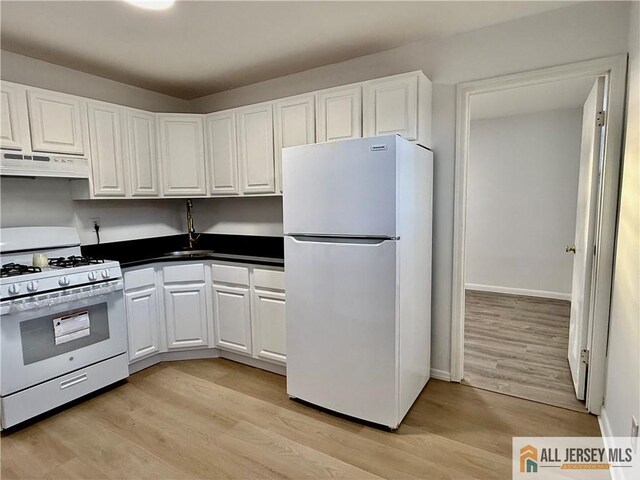 kitchen with white cabinetry, white appliances, and light hardwood / wood-style flooring