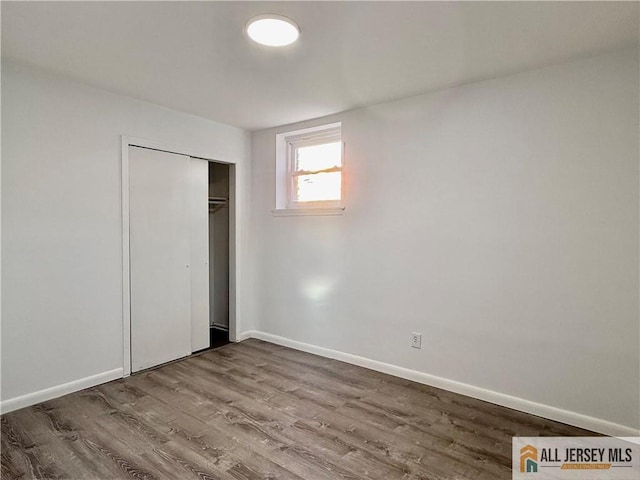 unfurnished bedroom with wood-type flooring and a closet