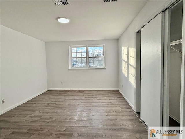 unfurnished bedroom with a closet and light wood-type flooring