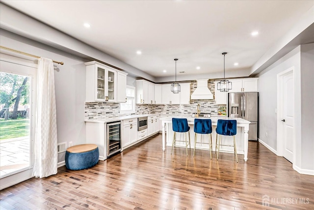 18 Rosewood Rd, Edison, NJ 08817 - kitchen featuring wood finished floors, a breakfast bar area, decorative backsplash, light countertops, and appliances with stainless steel finishes
