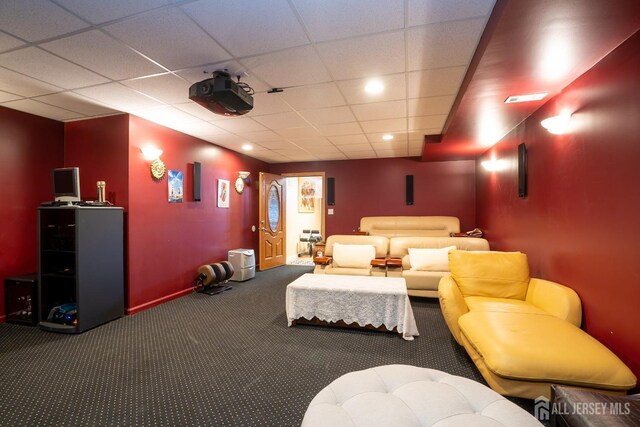 cinema with a paneled ceiling and carpet flooring