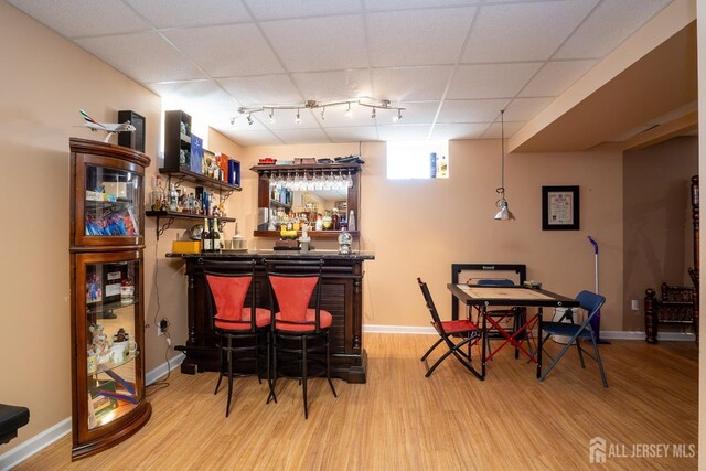 bar featuring a paneled ceiling and hardwood / wood-style floors