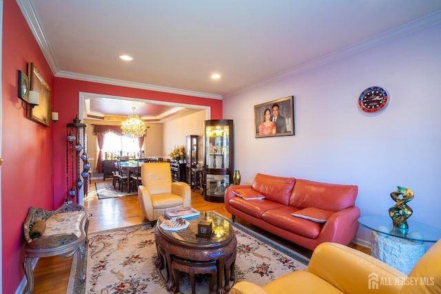 living room featuring an inviting chandelier, wood-type flooring, and ornamental molding