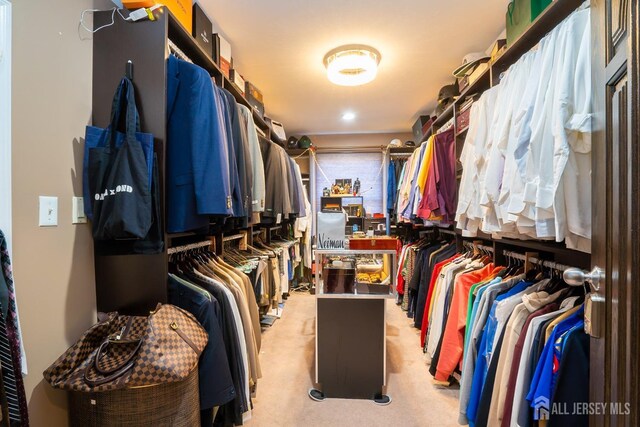 walk in closet featuring light carpet