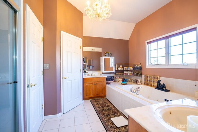 bathroom featuring vaulted ceiling, tile patterned flooring, vanity, a relaxing tiled tub, and a notable chandelier