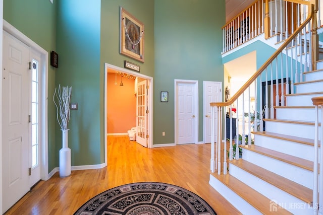 foyer with a high ceiling and wood-type flooring