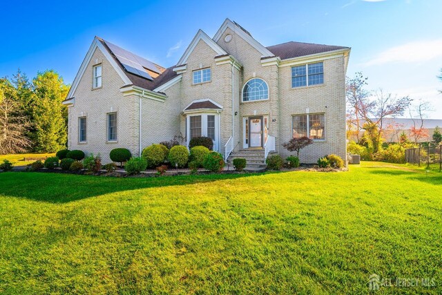 view of front of house featuring central AC unit and a front yard