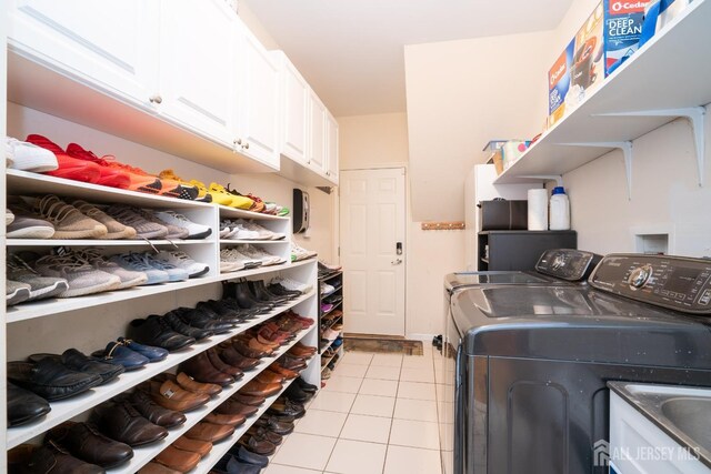 laundry room with cabinets, sink, washer and dryer, and light tile patterned floors