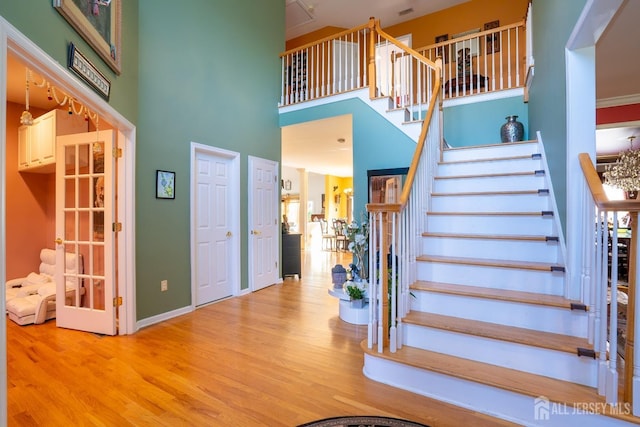 stairway featuring hardwood / wood-style flooring and a towering ceiling