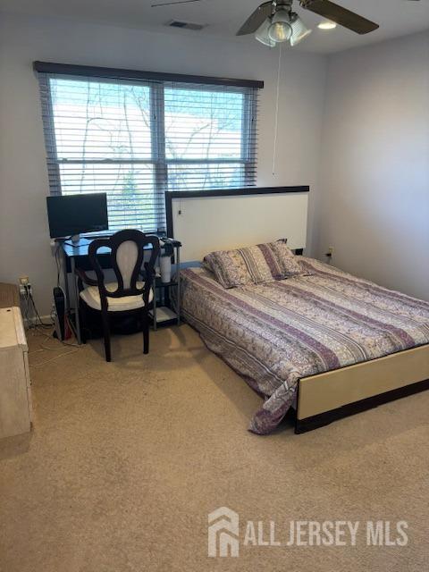 10 Eddie Ct, South Brunswick, NJ 08810 - carpeted bedroom featuring multiple windows, a ceiling fan, and an office area