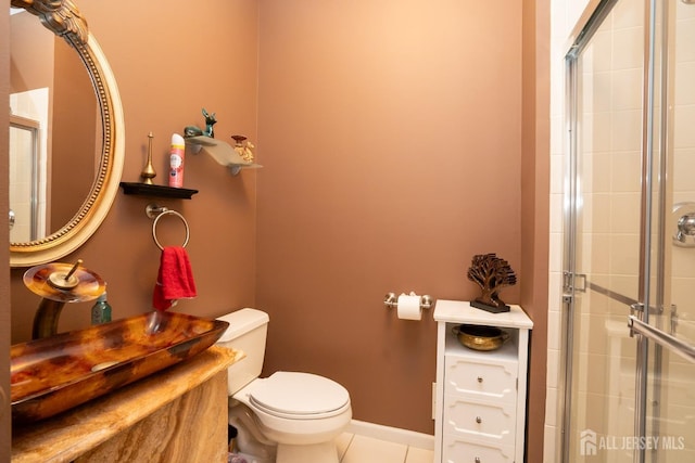 bathroom featuring a shower with door, tile patterned floors, and toilet