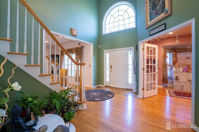 entryway featuring hardwood / wood-style floors and a high ceiling