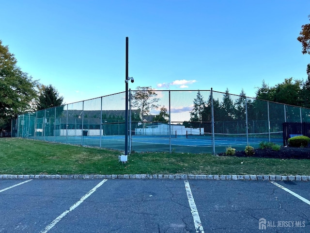 view of sport court featuring a lawn