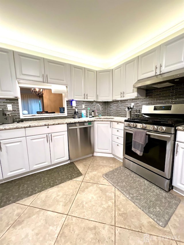 kitchen with white cabinetry, sink, decorative backsplash, light tile patterned floors, and stainless steel appliances